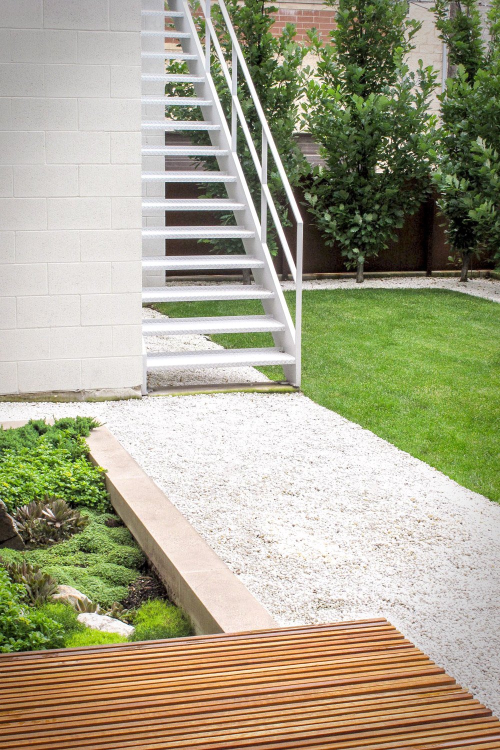 白色装饰石材作为现代后院设计的步道,建筑立面为白色。